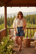 Plus size woman wearing glamorous tortoiseshell crystal rhinestone sunglasses in a warm cabin outdoor setting